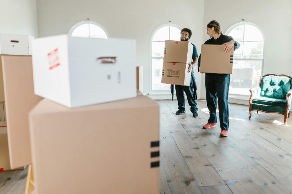 Two movers carrying furniture into a moving truck.