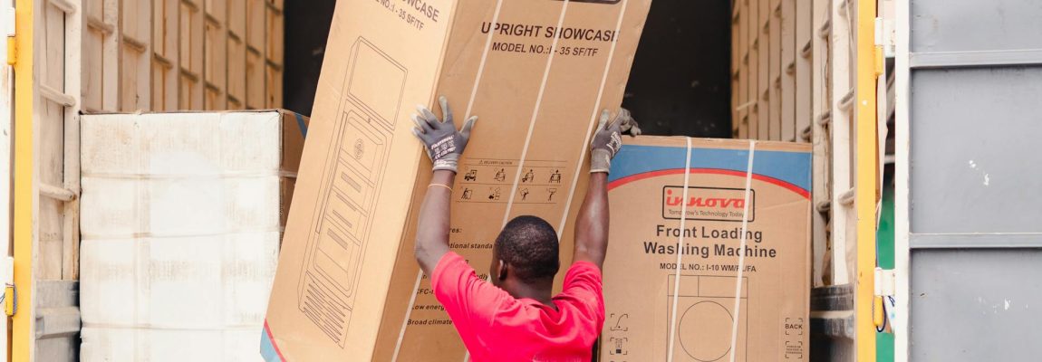 Two movers in blue uniforms carry furniture up a staircase during a professional relocation in Westlands.